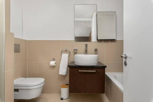 a bathroom with a sink and a toilet at Beachfront Penthouse with patio and free parking in Cape Town