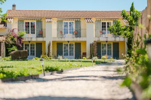 a house with a pathway in front of it at Logis Hotel des Granges in Arles
