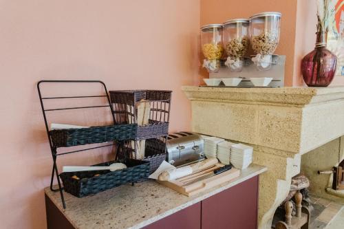 a room with a counter with a shelf with items on it at Logis Hotel des Granges in Arles