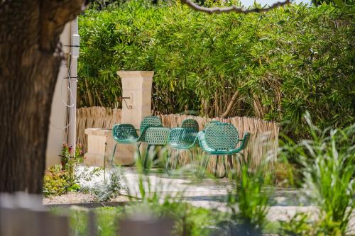 a group of chairs sitting next to a fence at Logis Hotel des Granges in Arles