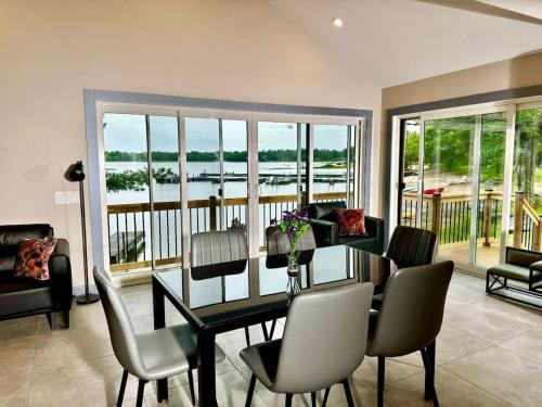 una sala da pranzo con tavolo, sedie e vista sull'acqua di Lakefront Studio Cottage #7 a Dillon
