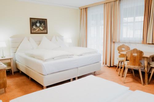 a bedroom with two beds and a table and chairs at Hotel Kohlpeter in Salzburg