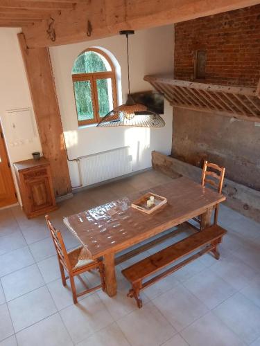 a wooden table and chairs in a room with a window at Chambre d'hôtes à la Ferme de la Porte en Aix pour 5 in Aix-en-Issart
