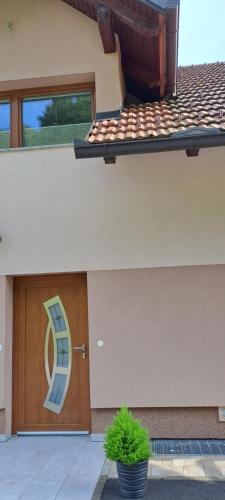 a house with a wooden door with a potted plant at Apartmaji Božiček in Podčetrtek