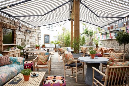 a patio with couches and tables and a table at Artist Residence Cornwall in Penzance