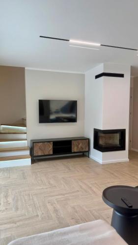 a living room with a tv on a wall at Leśne Sny - Kretowiny in Kretowiny
