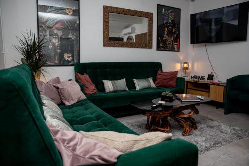 a living room with a green couch and a table at Studio '98 Apartments broj 31 in Sisak