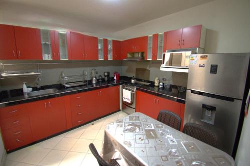 a kitchen with red cabinets and a table in it at La Casa del NONO in Cajamarca