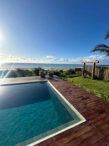 a swimming pool with a view of the ocean at Kamaiurá Pousada in Caraíva