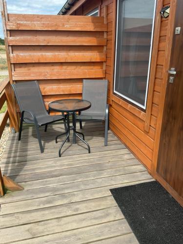a patio with two chairs and a table on a house at Apartamenty Cztery Siostry in Zastań
