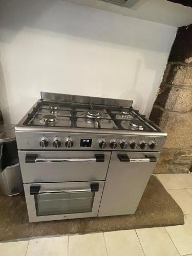 a stove top oven sitting in a kitchen at Kerkado in Ploumilliau