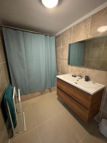 a bathroom with a sink and a mirror and a shower at Kerkado in Ploumilliau
