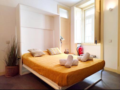 a bedroom with a large bed with two pillows at Casa do Sapalinho I - Setubal Downtown in Setúbal