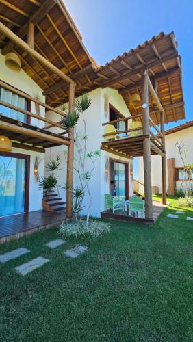 a patio of a house with a wooden pergola at Kamaiurá Pousada in Caraíva