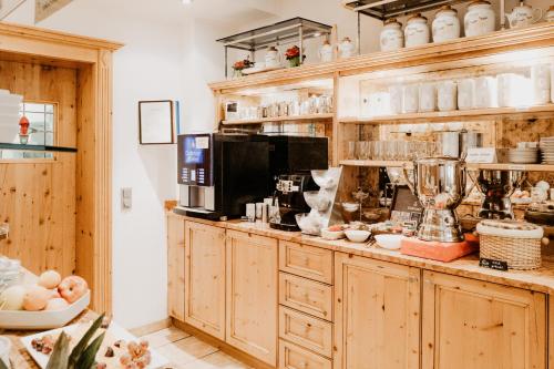 a kitchen with wooden cabinets and a counter with food at Hotel Kohlpeter in Salzburg