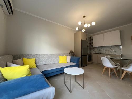 a living room with a couch and a table at Stylish Apartment 50m from Radhimë Beach in Vlorë