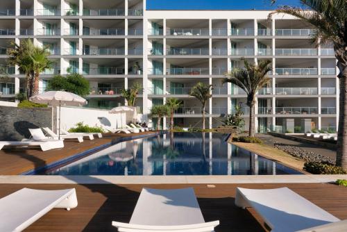 an image of a resort swimming pool with lounge chairs at Suite 107 in Funchal