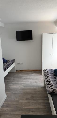 a room with two beds and a flat screen tv at Monteurzimmer A Simon in Jülich