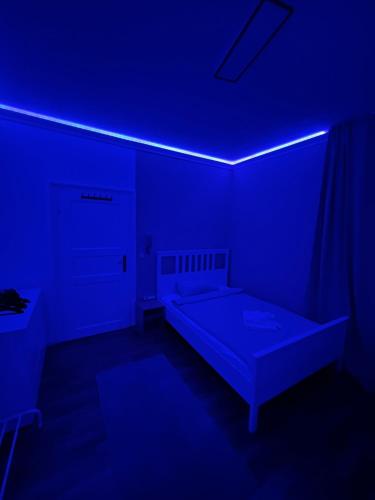 a dark room with a bed and a blue light at TOP Location Apartment Heidelberg Centrum near Hauptbahnhof, Bismarckplatz, Schloss in Heidelberg