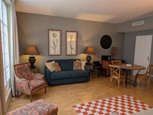 a living room with a blue couch and a table at Appartements Caumartin 64 in Paris