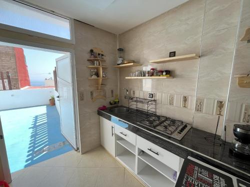 a kitchen with a sink and a stove in it at Sweet Taghazout Studios in Taghazout