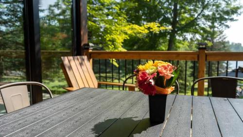 a vase of flowers sitting on a wooden table at Lake Muskoka 3-bdrm Cottage - Pier 100 #70 in Port Carling