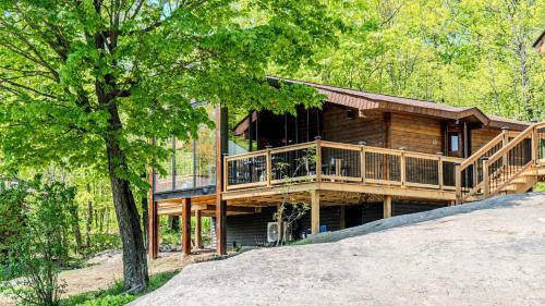 a log cabin with a deck in the woods at Muskoka Lakeview Cottage - Pier 100 #40 in Port Carling