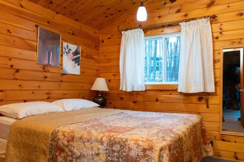 a bedroom with a bed in a log cabin at Lake Muskoka Deluxe 3-bdrm Cottage - Pier 100 #80 in Port Carling