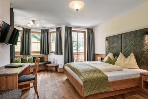 a hotel room with a bed and a desk with a computer at Aktivhotel Gasteiner Einkehr in Dorfgastein