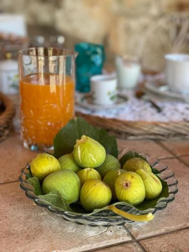 a plate of fruit on a table with a drink at Casale Filieri in SantʼElia Fiumerapido