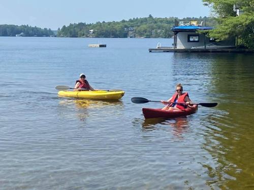 two people are in kayaks on a lake at Muskoka Lakefront 4-bdrm Guest House in Port Carling