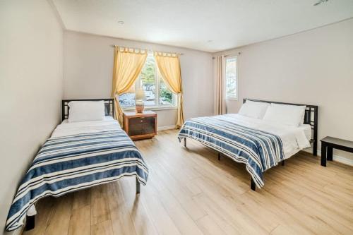a bedroom with two beds and a window at Muskoka Lakefront 4-bdrm Guest House in Port Carling