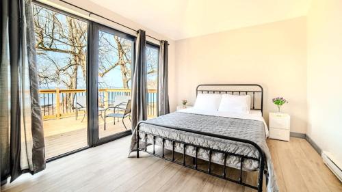 a bedroom with a bed and a balcony at 2-bedroom Lake Front Cottage in Harwood ON #2 in Harwood