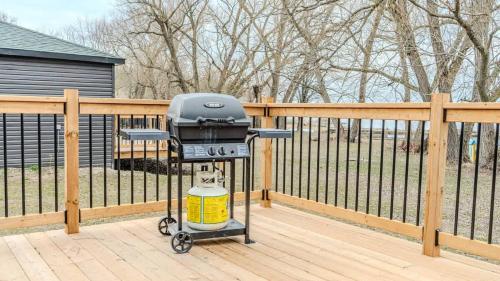 a grill sitting on a deck next to a fence at 2-bedroom Lake Front Cottage in Harwood ON #2 in Harwood