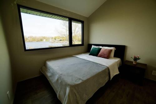 a bedroom with a bed with a large window at 1-bedroom Townhouse in Harwood #2 in Harwood