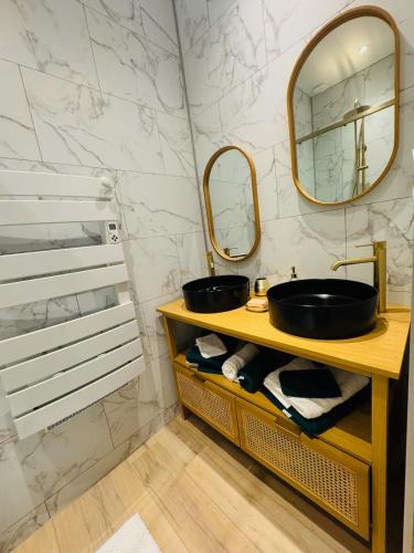 a bathroom with a sink and a mirror at Chez Rose Appartement cosy centre ville in Vichy