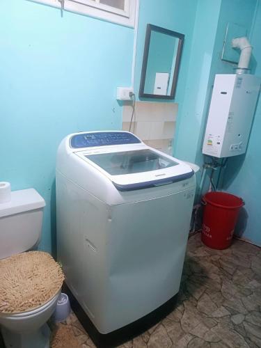 a bathroom with a washing machine and a toilet at Casa Central in Punta Arenas