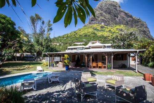 a house with a pool with a mountain in the background at Kitesurf Paradise at Le Morne - Pool, Garden, Views in Le Morne