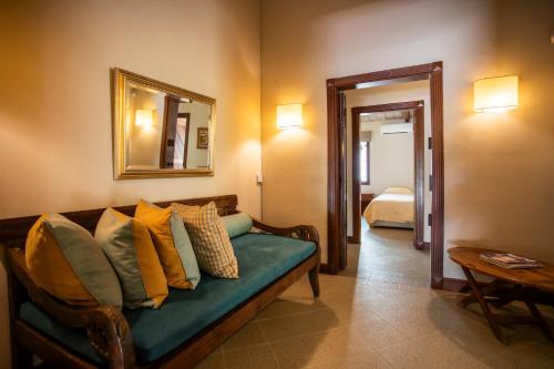 a living room with a couch with pillows and a mirror at Kitesurf Paradise at Le Morne - Pool, Garden, Views in Le Morne