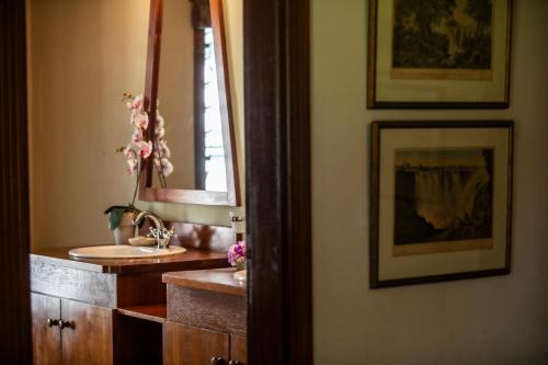 a bathroom with a sink and a mirror at Kitesurf Paradise at Le Morne - Pool, Garden, Views in Le Morne