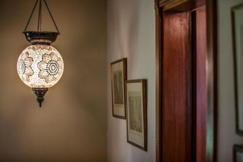 a light fixture hanging from a wall with pictures at Kitesurf Paradise at Le Morne - Pool, Garden, Views in Le Morne