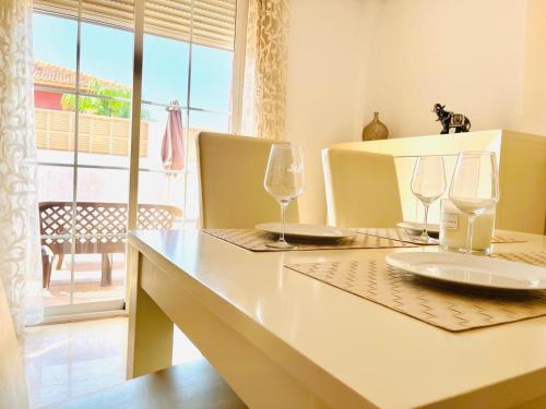 a table with two wine glasses on top of it at Sol y Relax en tu Chalet Pareado in Aguadulce