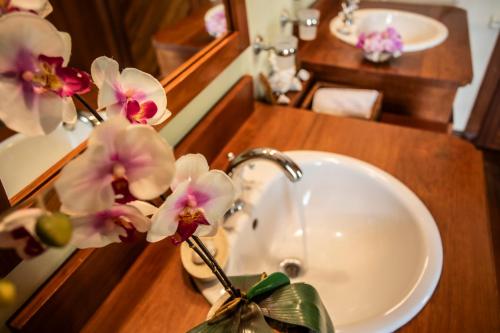 a bathroom sink with a vase with flowers in it at Kitesurf Paradise at Le Morne - Pool, Garden, Views in Le Morne