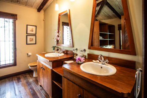 a bathroom with two sinks and a large mirror at Kitesurf Paradise at Le Morne - Pool, Garden, Views in Le Morne