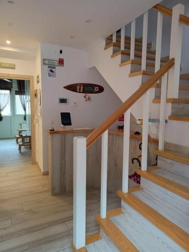 a staircase with a surfboard on the wall at Albergue La Magia del Camino in Comillas