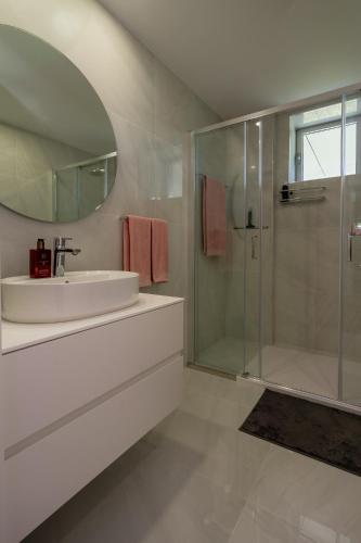 a white bathroom with a sink and a shower at Premium Stay Barcelos in Vila Boa