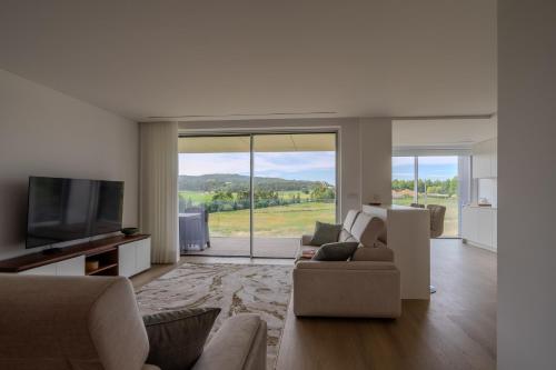 a living room with a couch and a television at Premium Stay Barcelos in Vila Boa