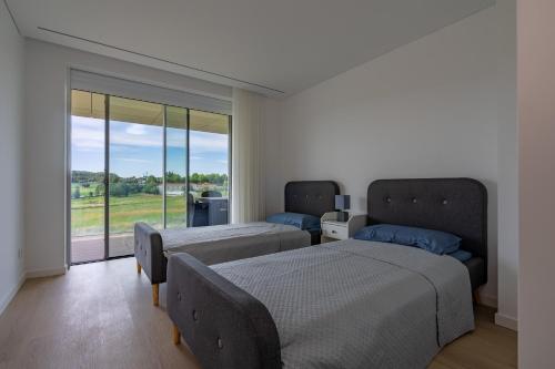 a bedroom with two beds and a large window at Premium Stay Barcelos in Vila Boa