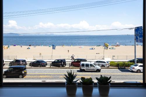 a view of a beach from a window with cars at The Beach Front Miurakaigan - Vacation STAY 10780 in Miura