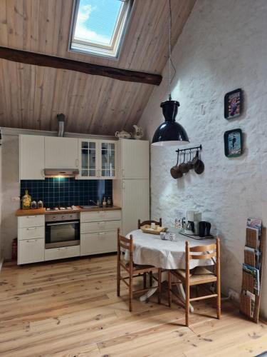 a kitchen with a table and a stove top oven at Gîte La Sarrée in Onlay